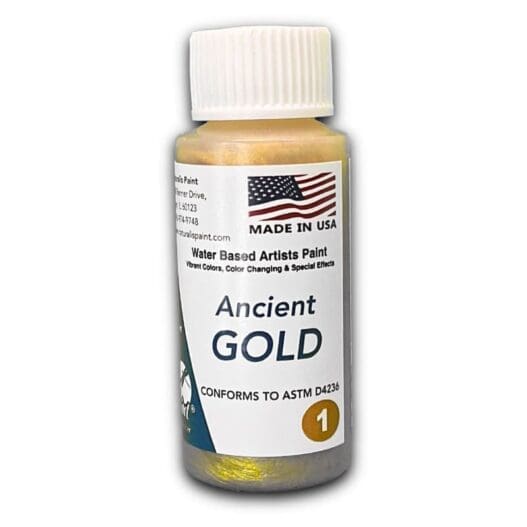 A small bottle of Ancient Gold water-based artist's paint, featuring a U.S. flag on the label, proudly states that it is made in the USA. The label also highlights its color-changing effects and compliance with ASTM D4236 standards.