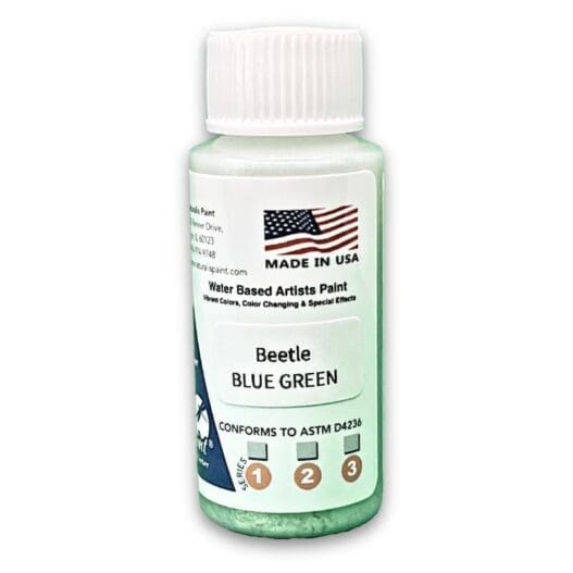 A small bottle of water-based artist's paint labeled "Bettle Blue Green," featuring an American flag and information on its conformity to ASTM standards.