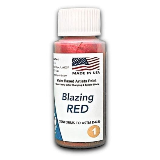 A bottle of Blazing Red artist paint, featuring an American flag design, labeled as made in the USA, and conforming to ASTM D4236 standards.