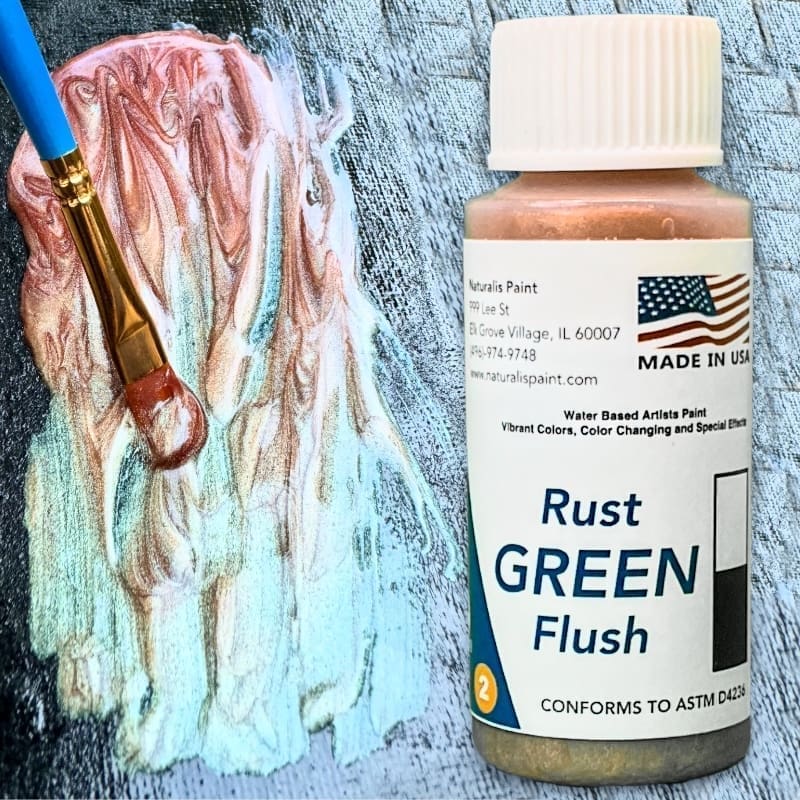 A bottle of Rust Green Flush water-based art paint sits next to a paintbrush applying the same color on a textured surface. The paint bottle is labeled with product details and features a Made in USA tag.