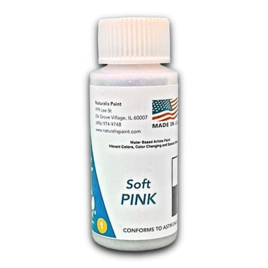 A small, white plastic bottle labeled "Soft Pink" filled with water-based artist paint. The label includes contact information, a U.S. flag, and a note about its vibrant colors and compliance with ASTM standards.